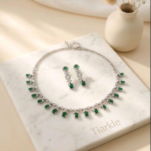 Tiarkle jewelry set featuring a silver-tone necklace and matching drop earrings with green and clear stones